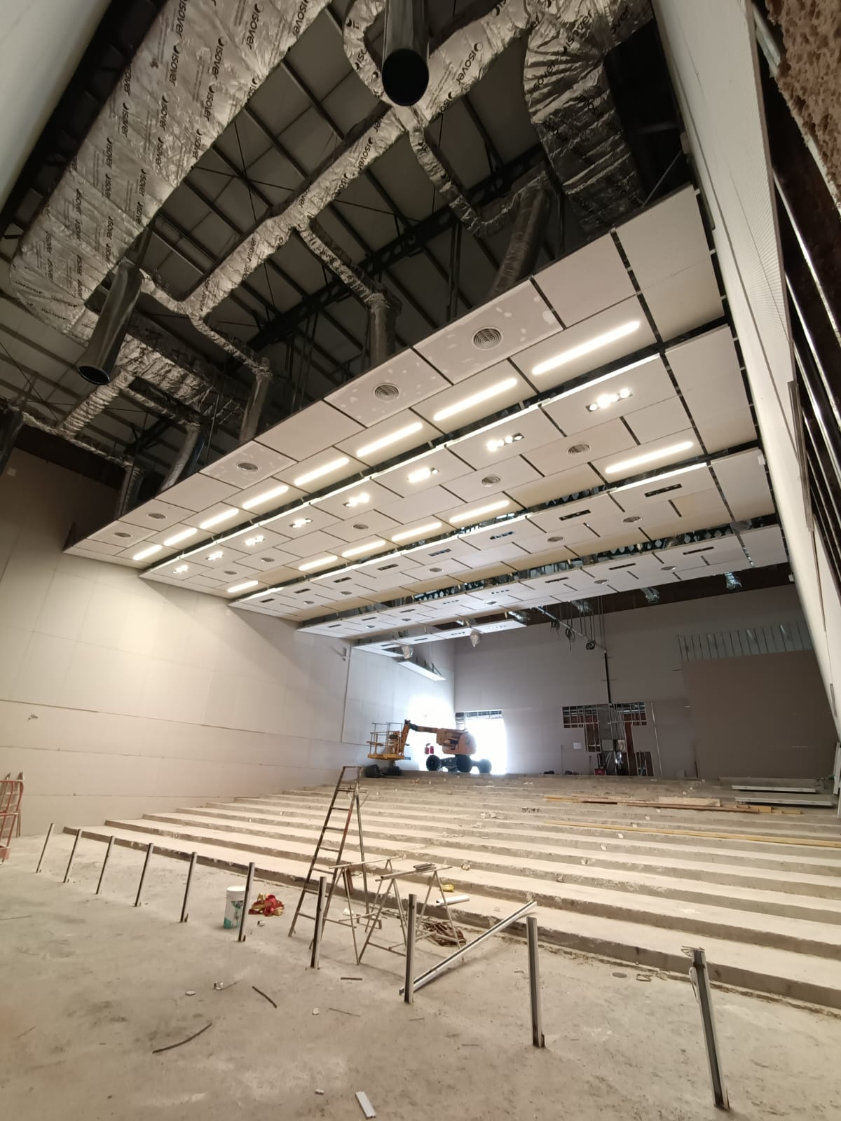 Interior de auditorio con paneles de cielorraso e instalaciones superiores